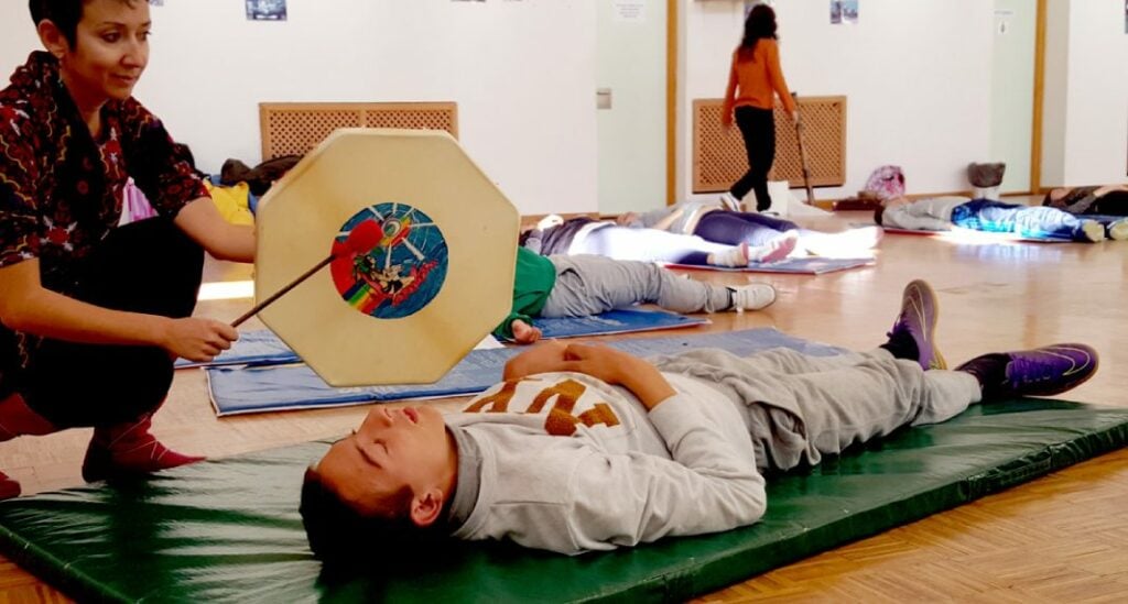 clase de niños haciendo yoga y técnicas de relajación